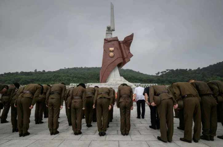 Des militaires de l'armée nord-coréenne se recueillent devant le monument de la Grande guerre de libération de la mère patrie, nom donné par la Corée du Nord à la guerre de Corée, à Pyongyang, le 27 juillet 2018, pour le 65e anniversaire de l'armistice.