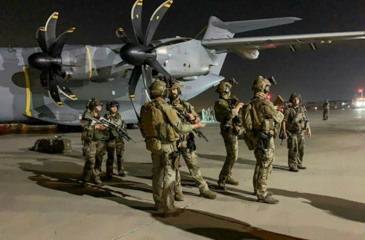 Des soldats français montent la garde près d'un avion militaire à l'aéroport de Kaboul le 17 août 2021