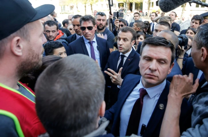 Emmanuel Macron (C) discute avec des manifestants opposés à ses réformes à Saint-Dié-des-Vosges, le 18 avril 2018