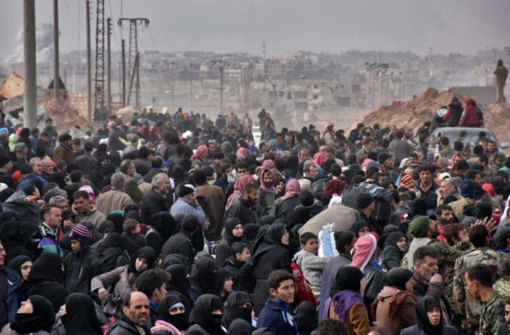 Des familles syriennes fuient les quartiers rebelles d'Alep et font la queue pour prendre des bus gouvernementaux ralliant la partie ouest de la ville contrôlée par le régime, le 29 novembre 2016 