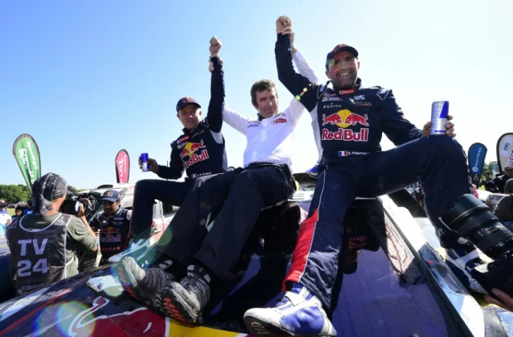 Le Français Stéphane Peterhansel (d) juché sur sa Peugeot célèbre sa victoire au Dakar, le 16 janvier 2016 à Rosario en Argentine