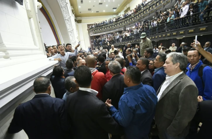 Des membres de l'Assemblée nationale vénézuelienne réagissent alors que des sympathisants du président Maduro pénètrent dans l'enceinte du bâtiment lors d'une session extraordinaire, le 23 octobre 2016 à Caracas