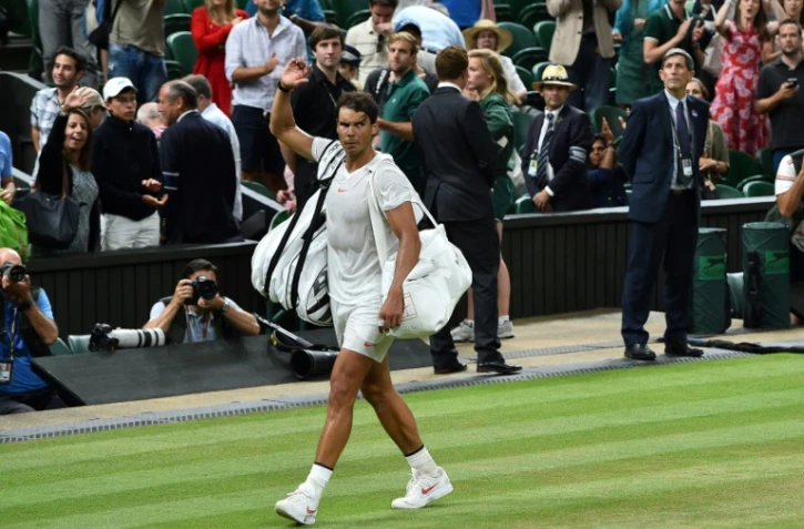 L'Espagnol Rafael Nadal quitte le court après la suspension par le couvre-feu de la demi-finale de Wimbledon face au Serbe Novak Djokovic le 13 juillet 2018