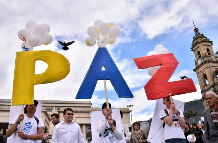 Des Colombiens brandissent le signe "Paix", le 26 septembre 2016, à Bogota,  pour célébrer l'accord de paix historique entre les Farc et le gouvernement