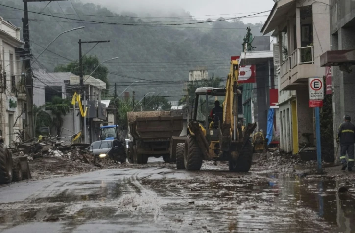 Un ouvrier nettoie une rue avec un engin de travaux après les inondations causées par de fortes pluies à Mucum, dans l'État du Rio Grande do Sul, au Brésil, le 10 mai 2024