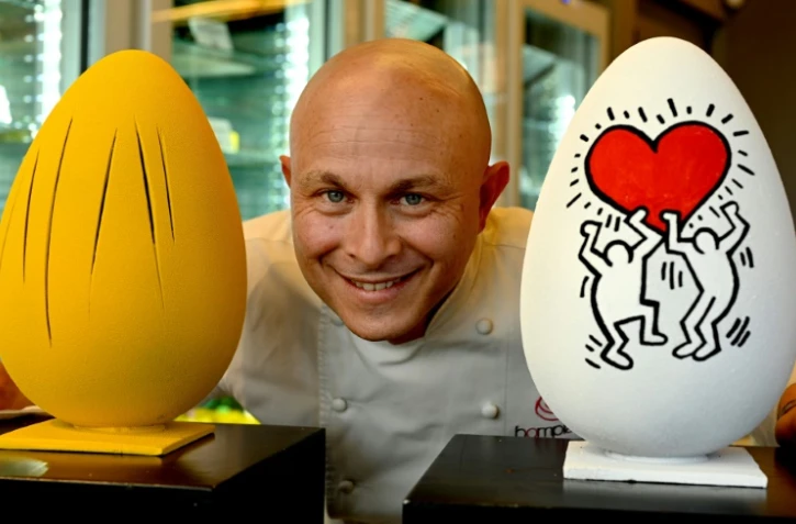 Le chef pâtissier Walter Musco et deux de ses créations, des oeufs de Pâques sculptés en hommage à divers artistes, le 30 mars 2021 à Rome