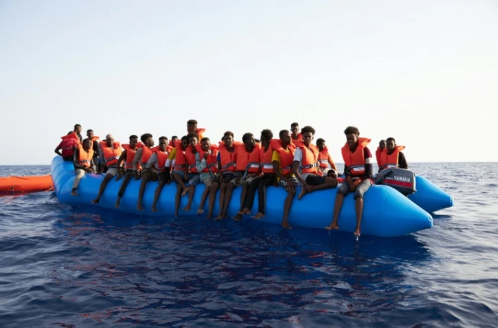 Photo prise et difffusée le 5 juillet 2019 par l'ONG allemande Sea-Eye montrant des migrants à bord d'un canot pneumatique surchargé repéré dans les eaux internationales au large de la Libye