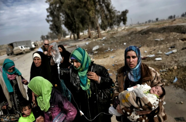 Des femmes et enfants fuient les combats à Mossoul entre les forces irakiennes et les jihadistes de l'EI, le 8 mars 2017