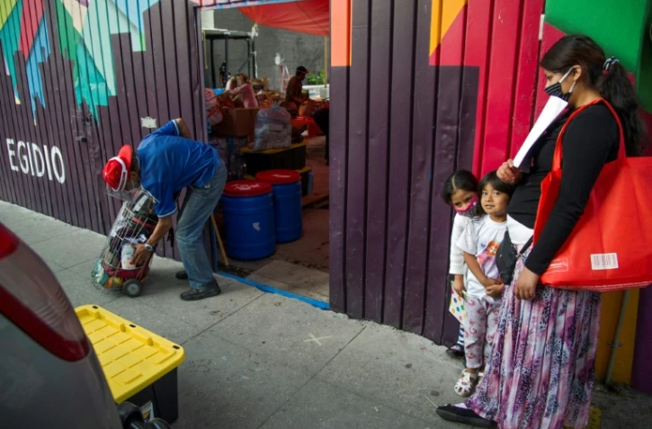 Une femme et ses filles font la queue pour obtenir un repas à Mexico City, le 10 juin 2020. La pandémie précipite dans l'extrême pauvreté de plus en plus de citadins dans le monde, selon la Banque mondiale