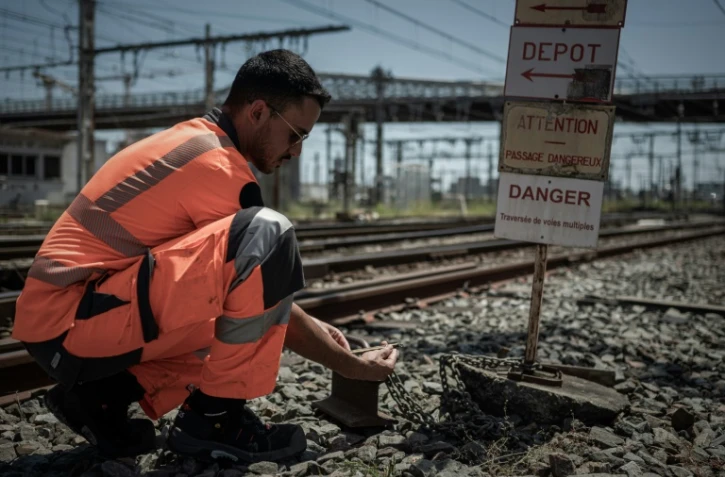 Un employé de la SNCF vérifie la température des voies ferrées à l'extérieur de la gare de Bordeaux, le 15 juin 2022
