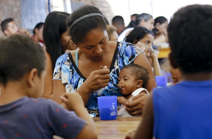 Une mère vénézuélienne nourrit son enfant dans un abri pour migrants, le 7 février 2019 à la frontière entre la Colombie et le Venezuela