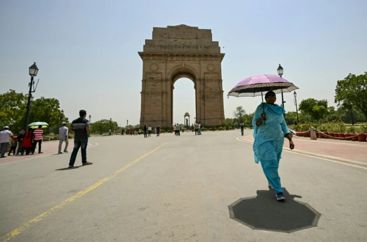Une passante avec un parasol près de la porte de l'Inde lors d'une forte canicule à New Delhi, le 29 mai 2024