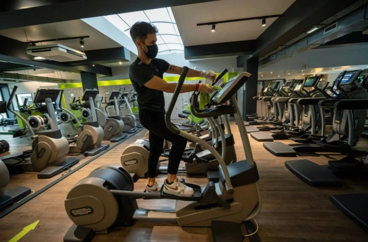 Un employé d'une salle de sports désinfecte une machine avant sa réouverture, le 7 juin 2021 à Strasbourg