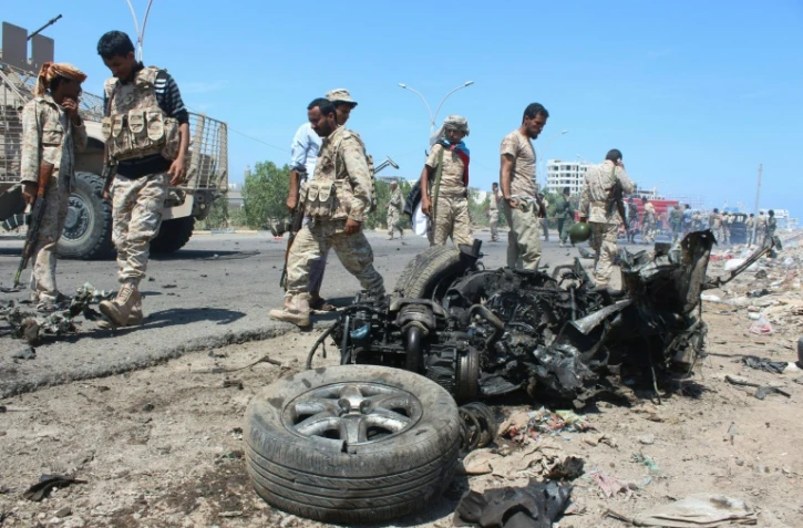 Les forces de sécurité yéménites inspectent le lieu de l'explosion d'une voiture piégée à Aden le 1er mai 2016