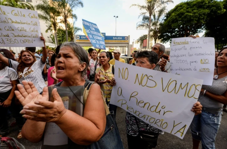 Des manifestants brandissent des pancartes demandant un référendum contre le président Nicolas Maduro, le 21 octobre 2016 à Caracas