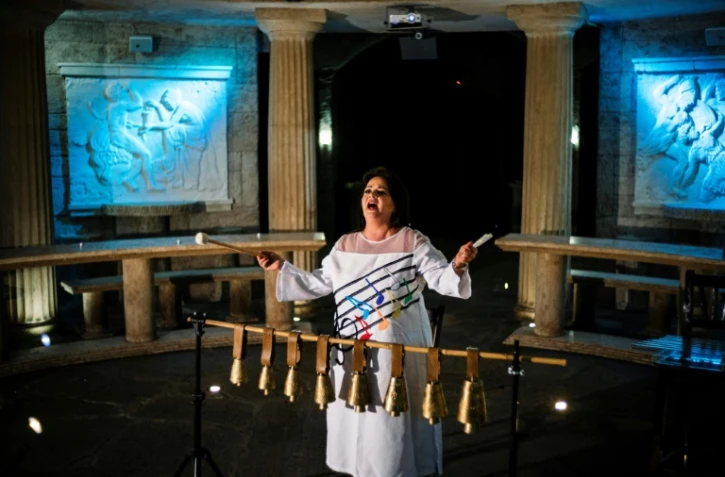 La chanteuse bulgare Smilyana Zaharieva chante en agitant des petites cloches, Ă Starosel, le 8 juillet 2019.