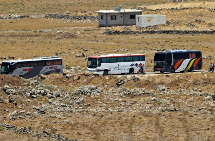 Des bus transportant des rebelles et des civils de la province syrienne de Qouneitra (sud-ouest) vers des zones insurgées dans la province d'Idleb (nord-ouest), après un accord avec la Russie, le 20 juillet 2018