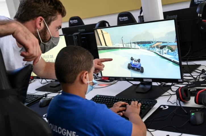 Un animateur donne des conseils à un enfant jouant à un jeu vidéo, le 22 juillet 2020 à Boulogne-Billancourt