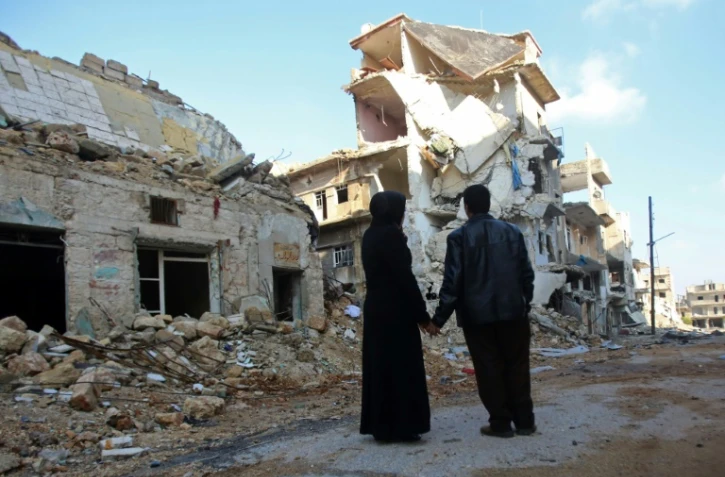 Un couple syrien à Alep devant leur maison dévastée, le 4 décembre 2016