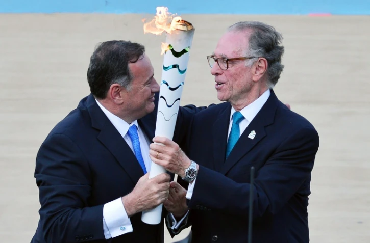 Le patron des Jeux de Rio Carlos Nuzman (d) reçoit la flamme olympique des mains de Spyros Kapralos, chef du comité olympique grec, le 27 avril 2016 à Athènes 