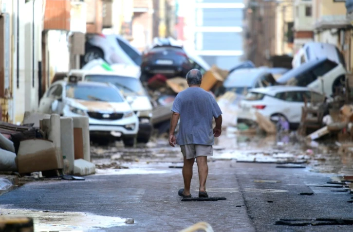 Un homme marche dans une rue dévastée par les inondations à Sedavi, près de Valence, dans l'est de l'Espagne, le 30 octobre 2024