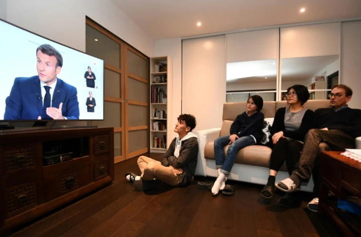 Famille française devant l'interview télévisée du président Emmanuel Macron, annonçant l'imposition de couvre-feux nocturnes, à Fouesnant (ouest), le 14 octobre 2020