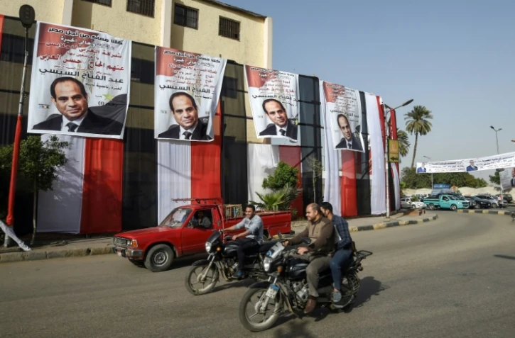 Des portraits du président Abdel Fattah al-Sissi placardés devant un bureau de vote au Caire, à la veille de la présidentielle, le 25 mars 2018