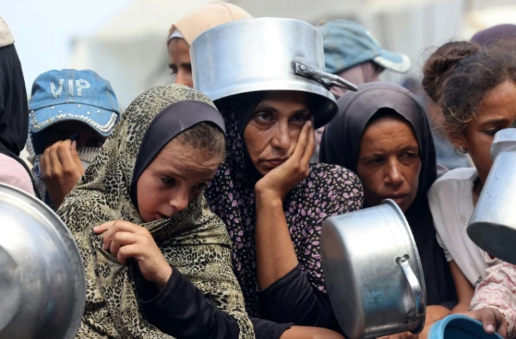 Des Palestiniens attendent une distribution de repas à Khan Younès, dans le sud de la bande de Gaza, le 21 août 2025