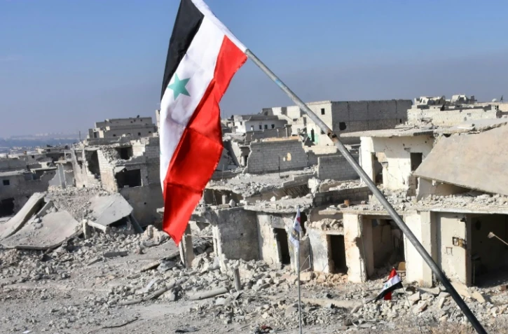Le drapeau syrien déployé le 12 décembre 2016 dans le quartier détruit de Sheikh Saeed à Alep