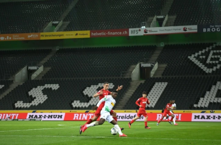 L'attaquant suisse du Borussia Mönchengladbach Breel Embolo à la lutte avec le milieu tunisien de Cologne Ellyes Skhiri (à gauche) lors du premier match à huis clos de l'histoire de la Bundesliga le 11 mars 2020