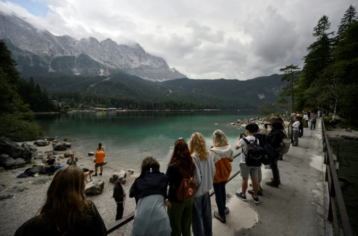 Des touristes admirent la vue du lac Eibsee, près de Garmisch-Partenkirchen, dans le sud de l'Allemagne, le 22 août 2025 