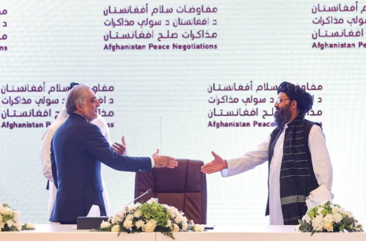 Le chef du Haut conseil pour la réconciliation nationale Abdullah Abdullah (G) et le chef de la délégation des talibans aux pourparlers de Doha, le mollah Abdul Ghani Baradar, le 18 juillet 2021 à Doha