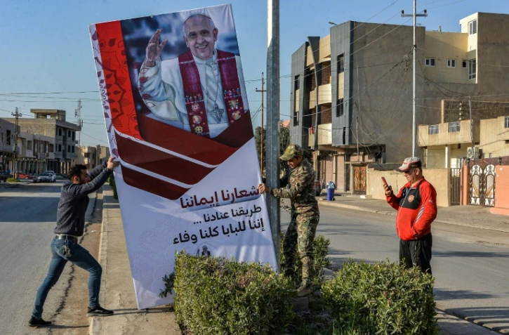 Une affiche annonçant la visite du pape France installée dans une rue de Qaraqoch, le 24 février 2021 en Irak