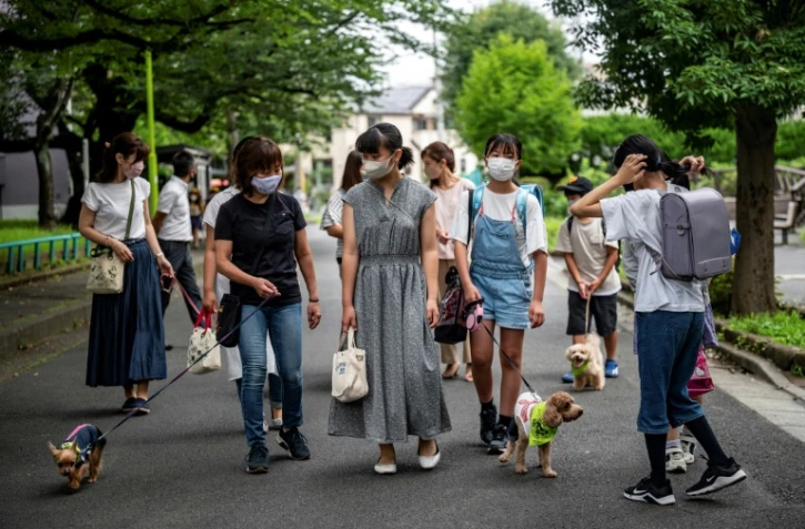 Des membres de la patrouille "Wan-Wan" ("ouaf ouaf" en japonais), dans une rue de Tokyo, le 14 juillet 2021
