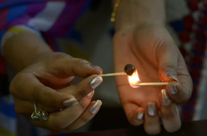 Une Pakistanaise fait chauffer une boulette de haschich, le 25 octobre 2017 Ă Peshawar