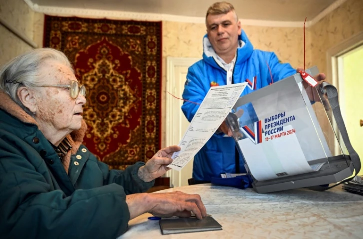 Une femme vote à son domicile pour l'élection présidentielle en Russie, à Sergiyev Posad, à 75 kilomètres de Moscou, le 16 mars 2024