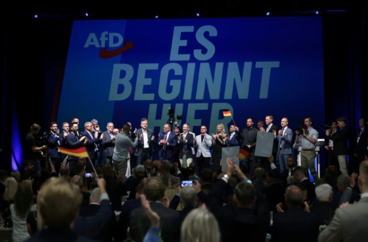 (g-d) Ulrich Siegmund, tête de liste du parti d'extrême droite Alternative pour l'Allemagne (AfD) aux élections régionales de Saxe-Anhalt, les coprésidents de l'AfD Tino Chrupalla et Alice Weidel et d'autres membres du parti chantent l'hymne national lors de la soirée électorale à Magdebourg, le 6 septembre 2026 dans l'est de l'Allemagne
