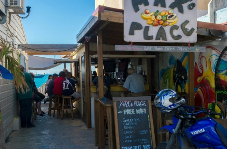 Des clients regardent un match de football dans un bar à Grand-Case, le 28 février 2018, sur l'île de Saint-Martin