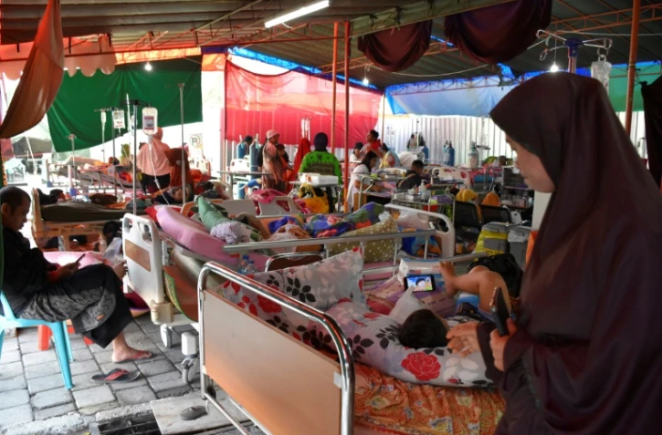Des blessés et leurs familles dans un hôpital de fortune à Mataram le 20 août 2018, sur l'île de Lombok en Indonésie, touchée par de multiples séismes