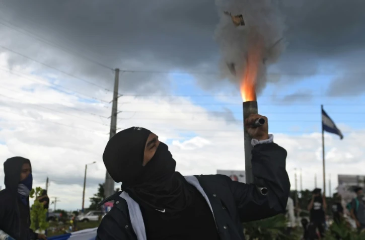 Un homme allume un mortier artisanal lors d'une manifestation Ă Managua au Nicaragua, le 4 juillet 2018