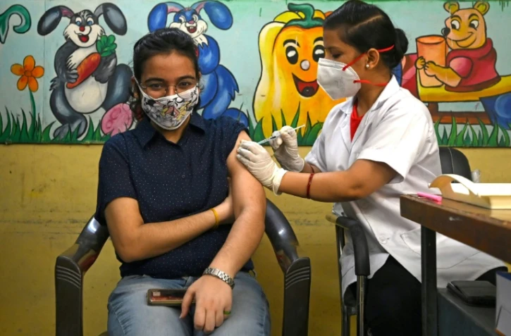 Une infirmière administre une dose de vaccin anti Covid-19 dans un centre de vaccination de New Delhi le 21 juin 2021