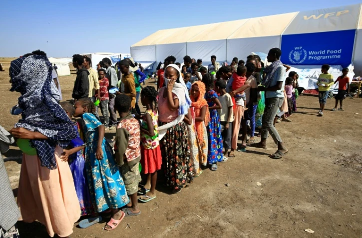Des Ethiopiens, qui ont fui les combats dans la région du Tigré, attendent une distribution de nourriture, le 27 novembre 2020 dans un camp de réfugiés à Hamdayti, au Soudan