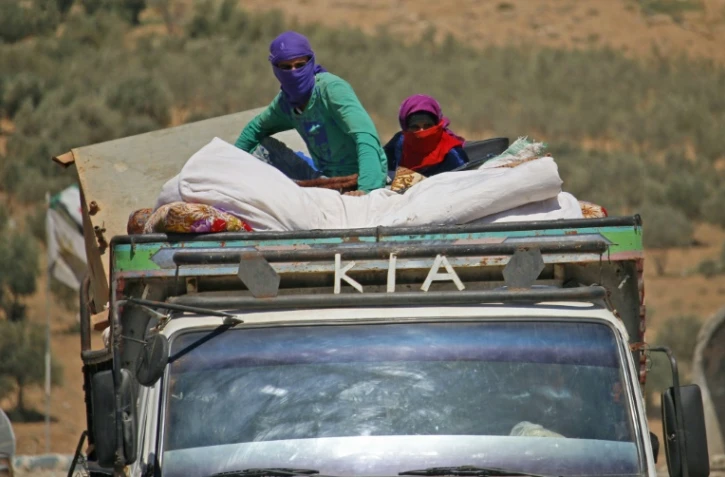 Des habitants fuient le 26 juin 2018 les violences dans les secteurs rebelles de la province de Deraa, dans le sud de la Syrie, où les forces du régime mènent lancé une offensive