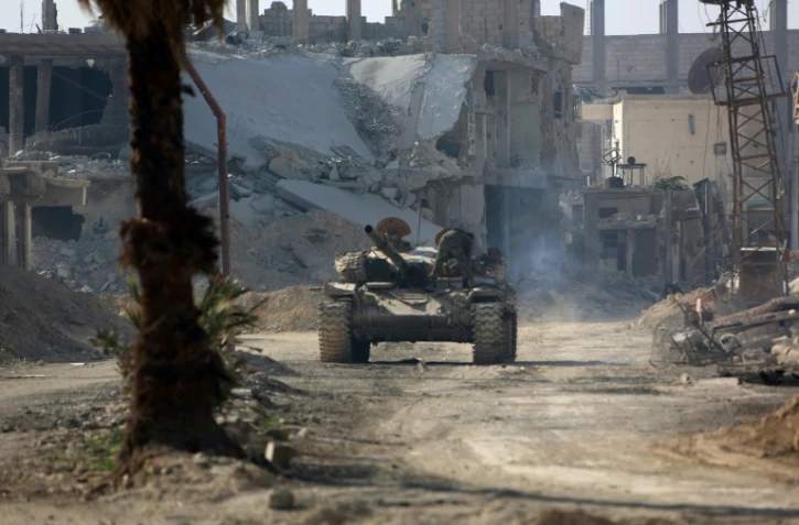 Un tank de l'armée syrienne avance dans l'ancienne localité rebelle de Beit Nayem dans la Ghouta orientale, le 6 mars 2018