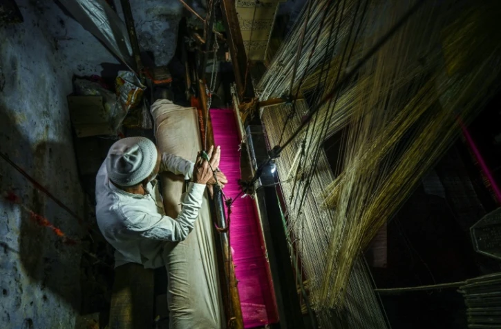 Tissage traditionnel d'un sari sur un métier à bras dans un atelier de Varanasi, le 20 novembre 2021 en Inde