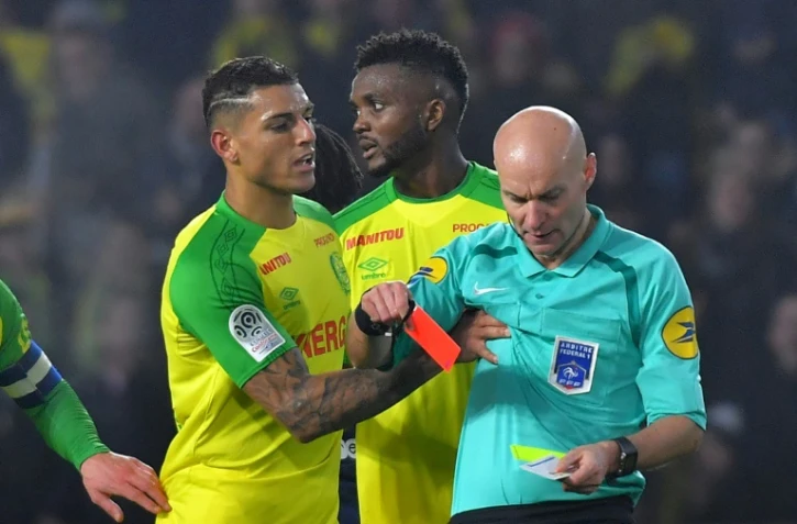 Le défenseur de Nantes Diego Carlos (g) reçoit un carton rouge par l'arbitre Tony Chapron à La BeaUjoire, le 14 janvier 2018