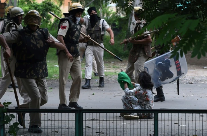 Un adepte de Gurmeet Ram Rahim Singh face aux forces de l'ordre indiennes lors de heurts après la condamnation pour viol du gourou, le 25 août 2017 à Panchkula