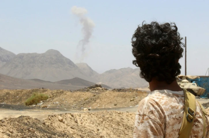 Un soldat fidèle au président président Abd Rabbo Mansour Hadi regarde la fumée s'élever sur les collines de Sirwah, dans la province de Marib, au cours d'affrontements avec les rebelles chiites, le 10 avril 2016