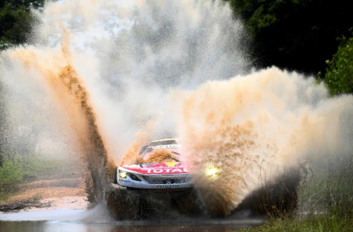La Peugeot de Stéphane Peterhansel prise dans une flaque d'eau sur la route de la 2e étape du Dakar, vers Resistencia, le 2 janvier 2017