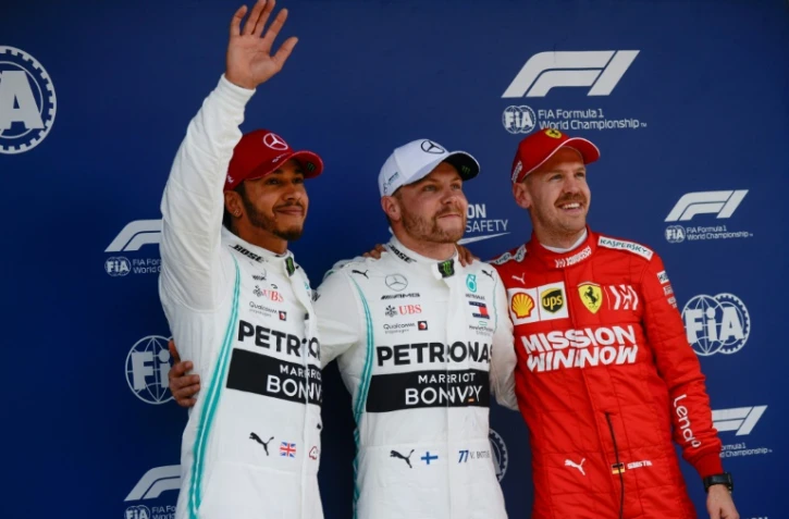 Valtteri Bottas (c/Mercedes) posent avec Lewis Hamilton (g/Mercedes) et Sebastian Vettel (Ferrari) après avoir obtenu la pole position pour le GP de Chine, le 13 avril 2019 à Shanghai
